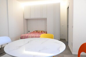 A compact room with a bed, a round table, and two chairs. - SE193 – Senigallia, brand-new studio with air conditioning (Senigallia)