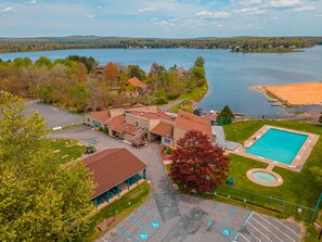 Vista aerea di una proprietà sul lago con piscina, un padiglione coperto e un parcheggio con posti auto riservati ai disabili.