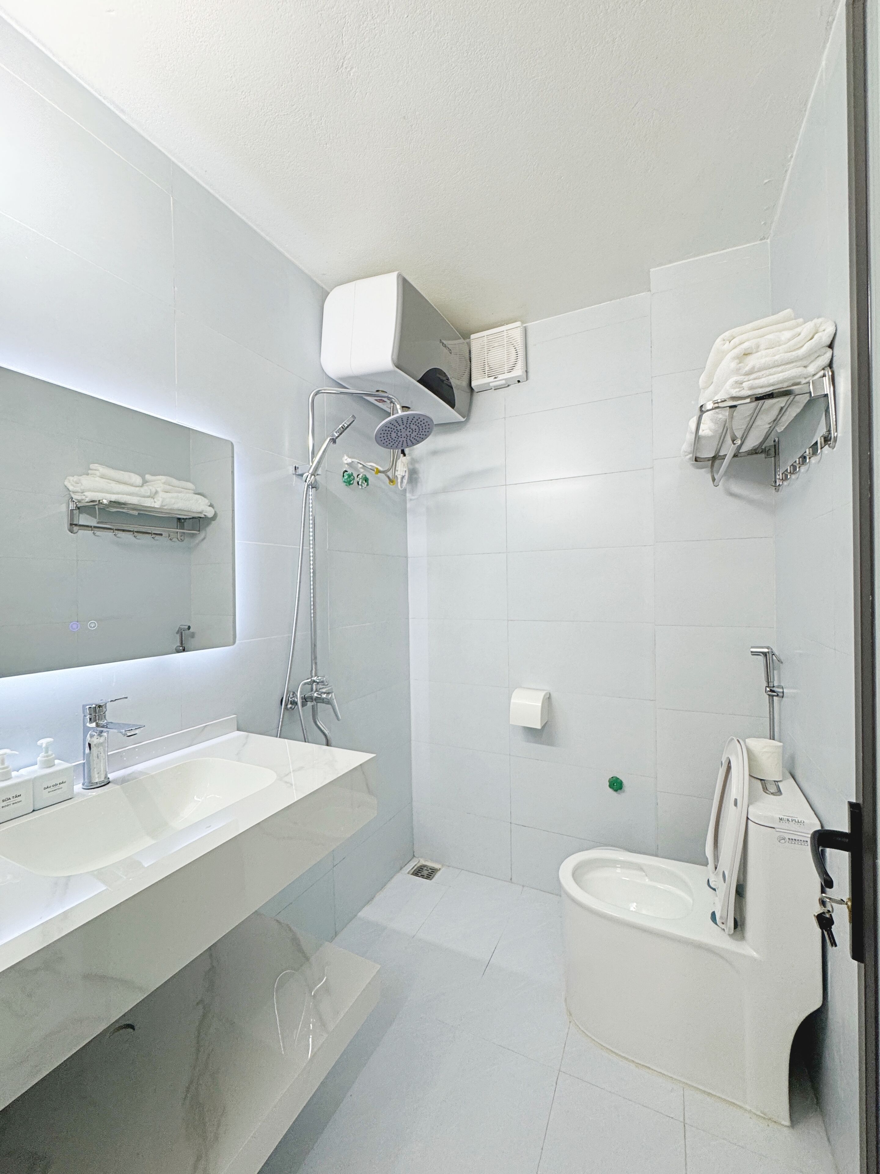 Un baño moderno con dos lavamanos, ducha y retrete.
