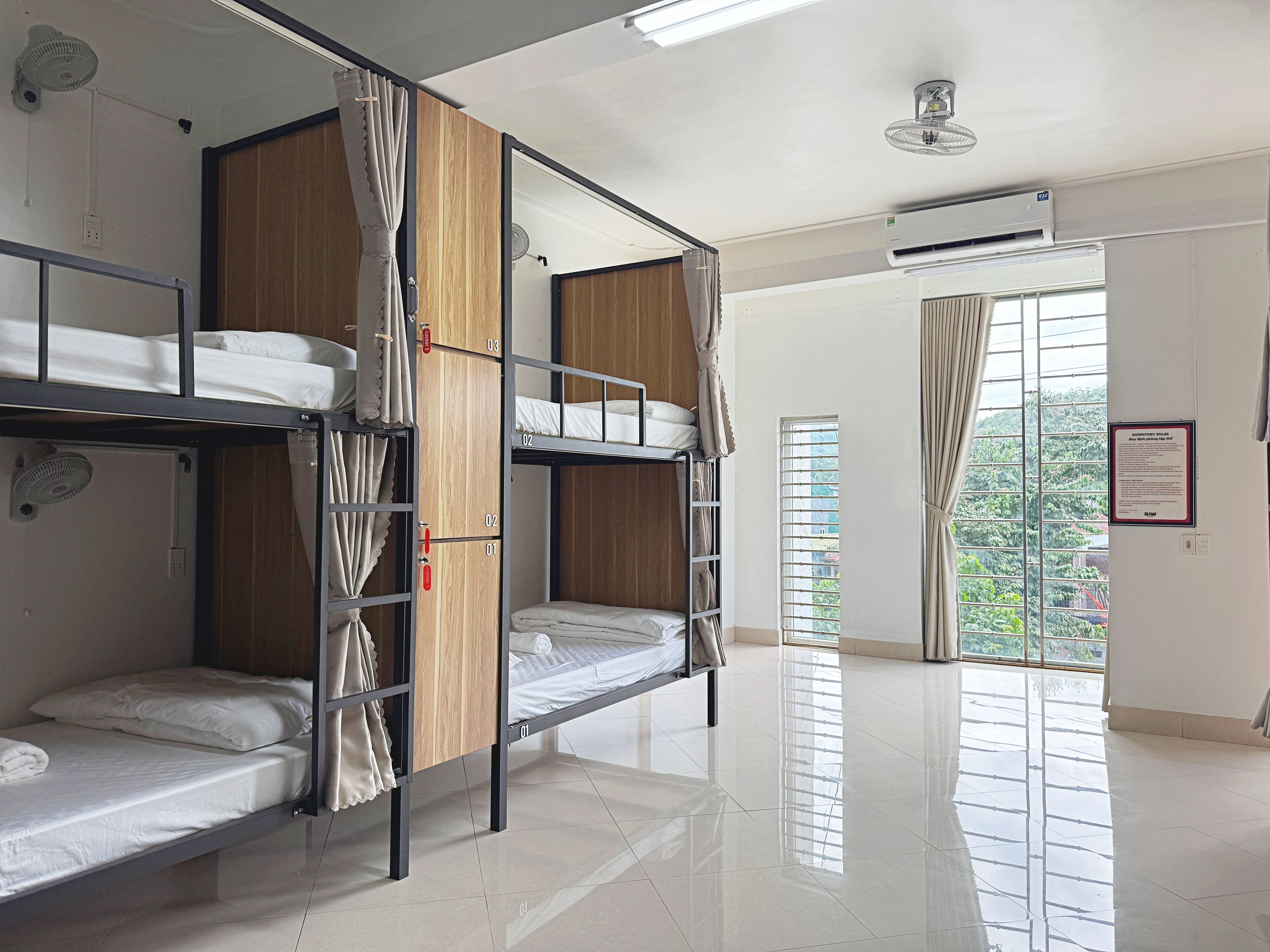 A bunk room with bunk beds, a ceiling fan, an air conditioning unit, and a window with blinds.