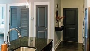 Una cocina moderna con un lavamanos de acero inoxidable, suelo de madera oscura y lavavajillas empotrado.