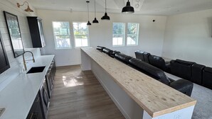 A modern kitchen with a central island, black cabinetry, and pendant lighting. - Spacious 6 bedroom home with theater room and gym just minutes from Yakima! (Selah)