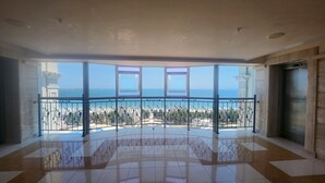 A spacious balcony with a clear view of the sea and a tiled floor.
