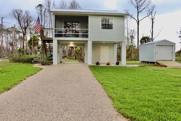 Front of exterior. House is on stilts and you must use stairs to enter.