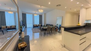 A modern living room with a dining area, large windows, and a kitchen. - Modern 2BR | 60th Floor Views in Business Bay (دبي)