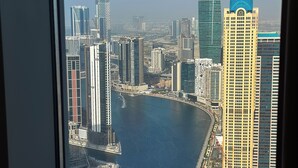 A high-rise building with a view of a river and a bridge. - Modern 2BR | 60th Floor Views in Business Bay (دبي)