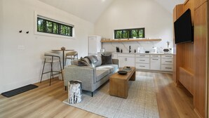 A modern kitchen with white cabinets, a wooden countertop, and a built-in oven. - Nature's Loft | Hocking Hills, New Modern Cabin (Rockbridge)