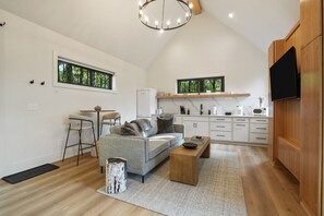 A modern kitchen with white cabinets, a wooden countertop, and a built-in oven.