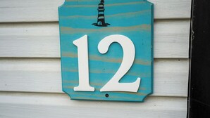 Una placa con el número de la casa, con diseño de faro.