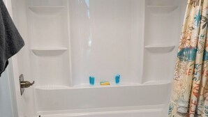 Un baño con bañera, inodoro y cortina de ducha.