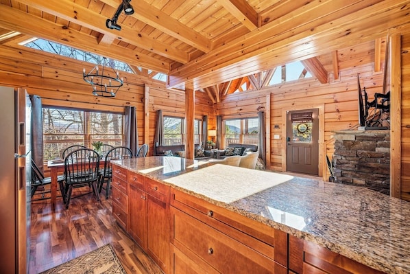 A spacious kitchen with granite countertops, wooden cabinets, and a large island.