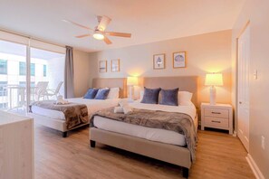 A hotel room with two beds, a balcony, a ceiling fan, and framed artwork on the wall. - Grand 1BR | Free Parking | Near Bayfront Park (Miami)