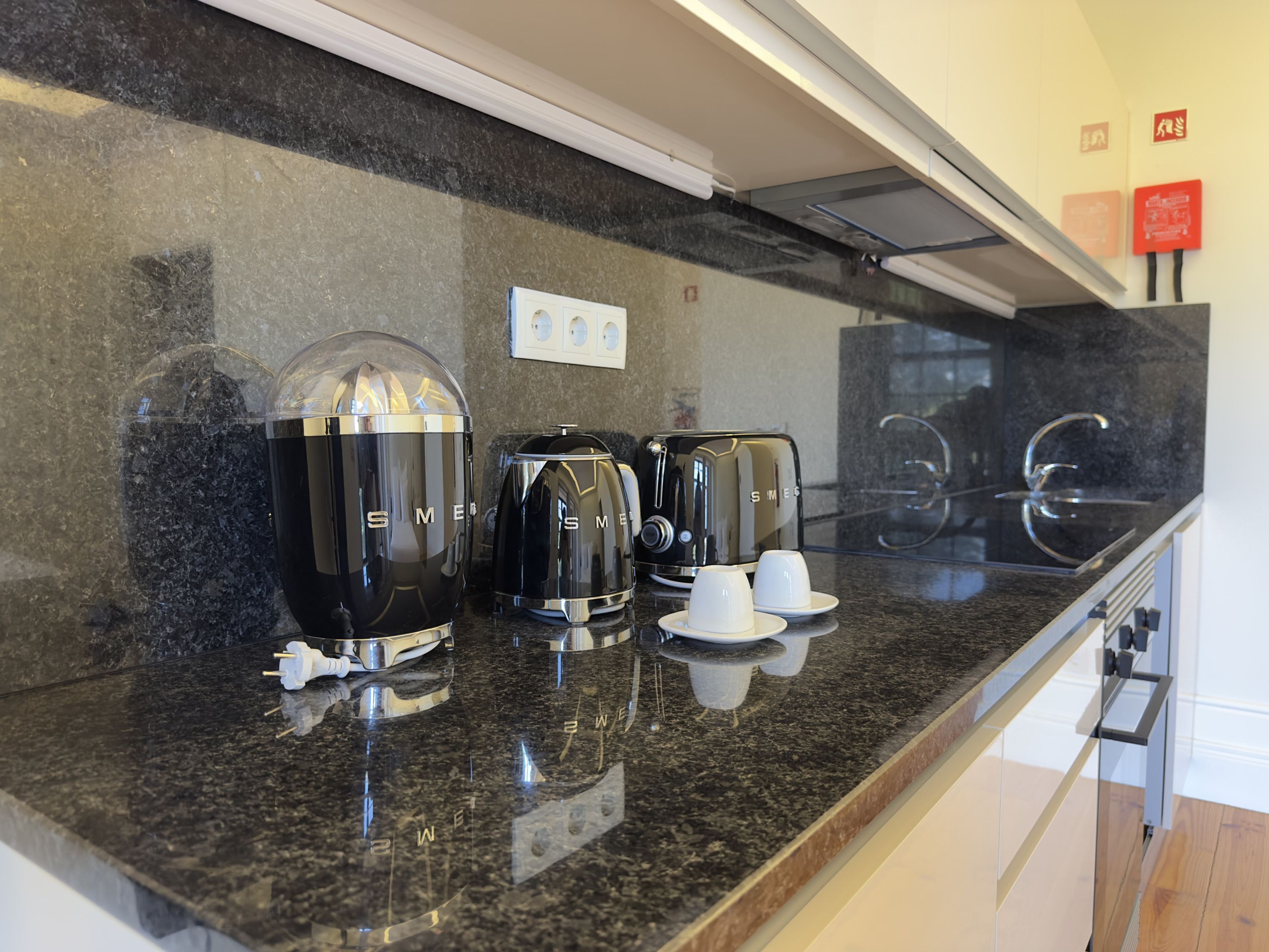 A kitchen counter with a coffee maker, a toaster, and a kettle.