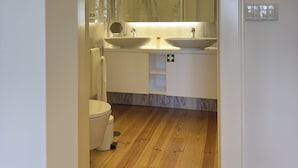 A modern bathroom with a wooden floor, two sinks, a mirror, and a toilet. - Collection 3T in Oporto (Porto)
