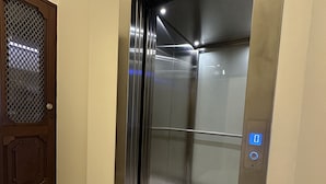 An elevator with a metallic interior and a control panel with a blue light. - Collection 3T in Oporto (Porto)