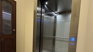 An elevator with a metallic interior and a control panel with a blue light. - Collection 3F in Oporto (Porto)