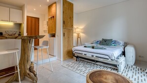 A modern bedroom with a bed, bedside table, and a wooden floor lamp.