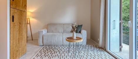 A modern living room with a sofa, a wooden coffee table, and a lamp.