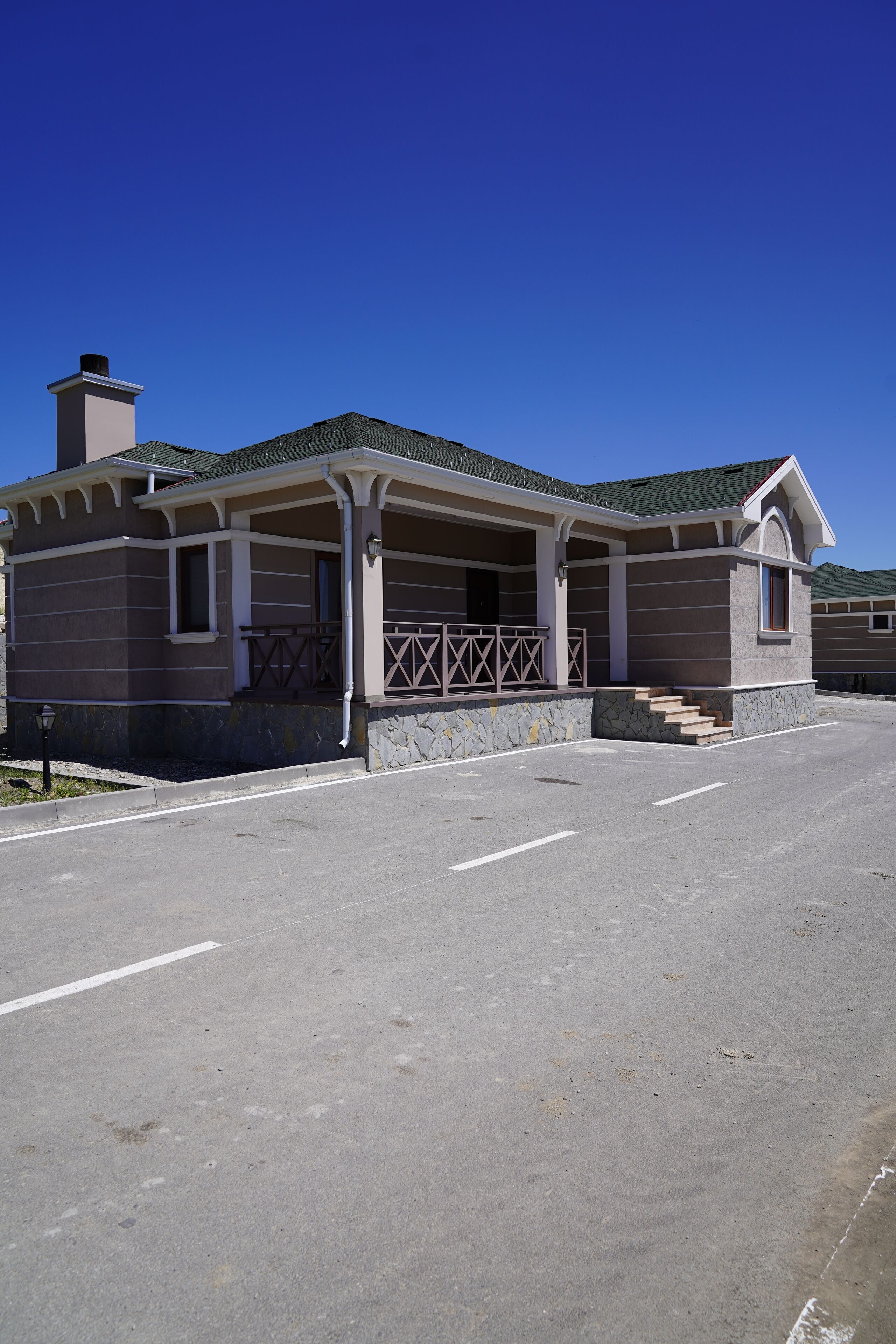 A building with a covered porch and stone steps leading to the entrance.