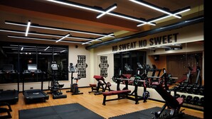 A gym with treadmills, weight machines, and a wall with motivational quotes. - Green Village Hotel and Spa  (Samaxi)