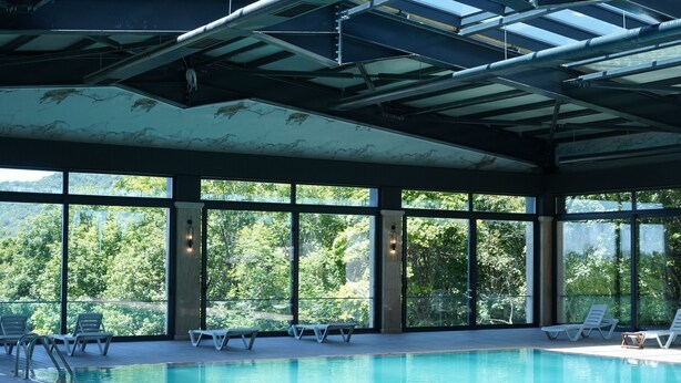 An indoor swimming pool with clear views of the surrounding forest. - Green Village Hotel and Spa  (Samaxi)