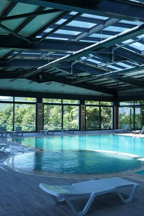 An indoor swimming pool with clear views of the surrounding forest. - Green Village Hotel and Spa  (Samaxi)