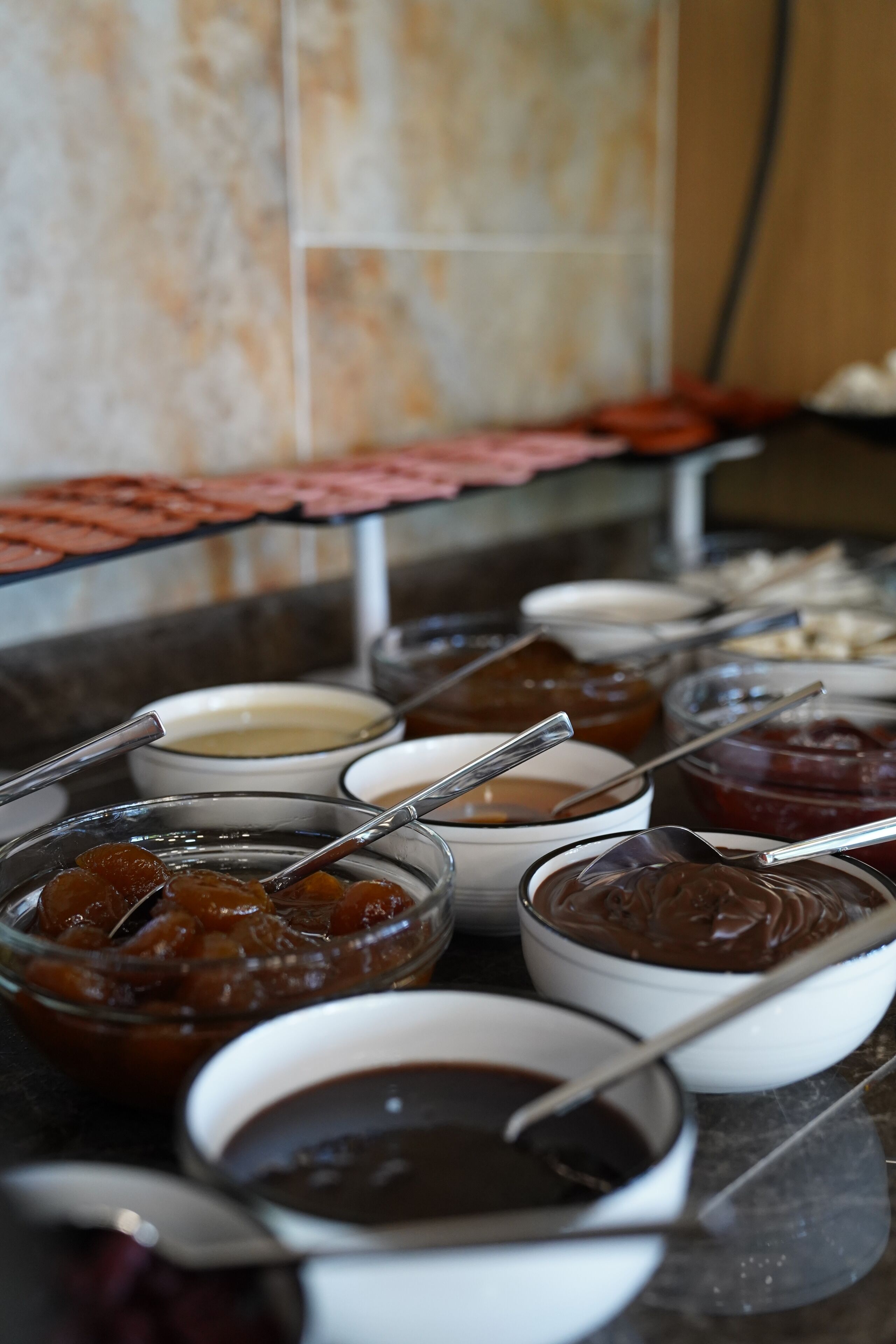 Un buffet proposant divers plats et des bols, notamment un saladier en verre contenant une sauce foncée et un bol blanc contenant une sauce blanche.