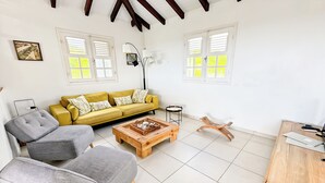 Un salon comprenant un canapé, un fauteuil, une table basse et un meuble en bois.