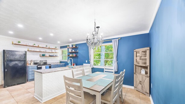 Una cocina moderna con una isla central, armarios de madera y un refrigerador empotrado.