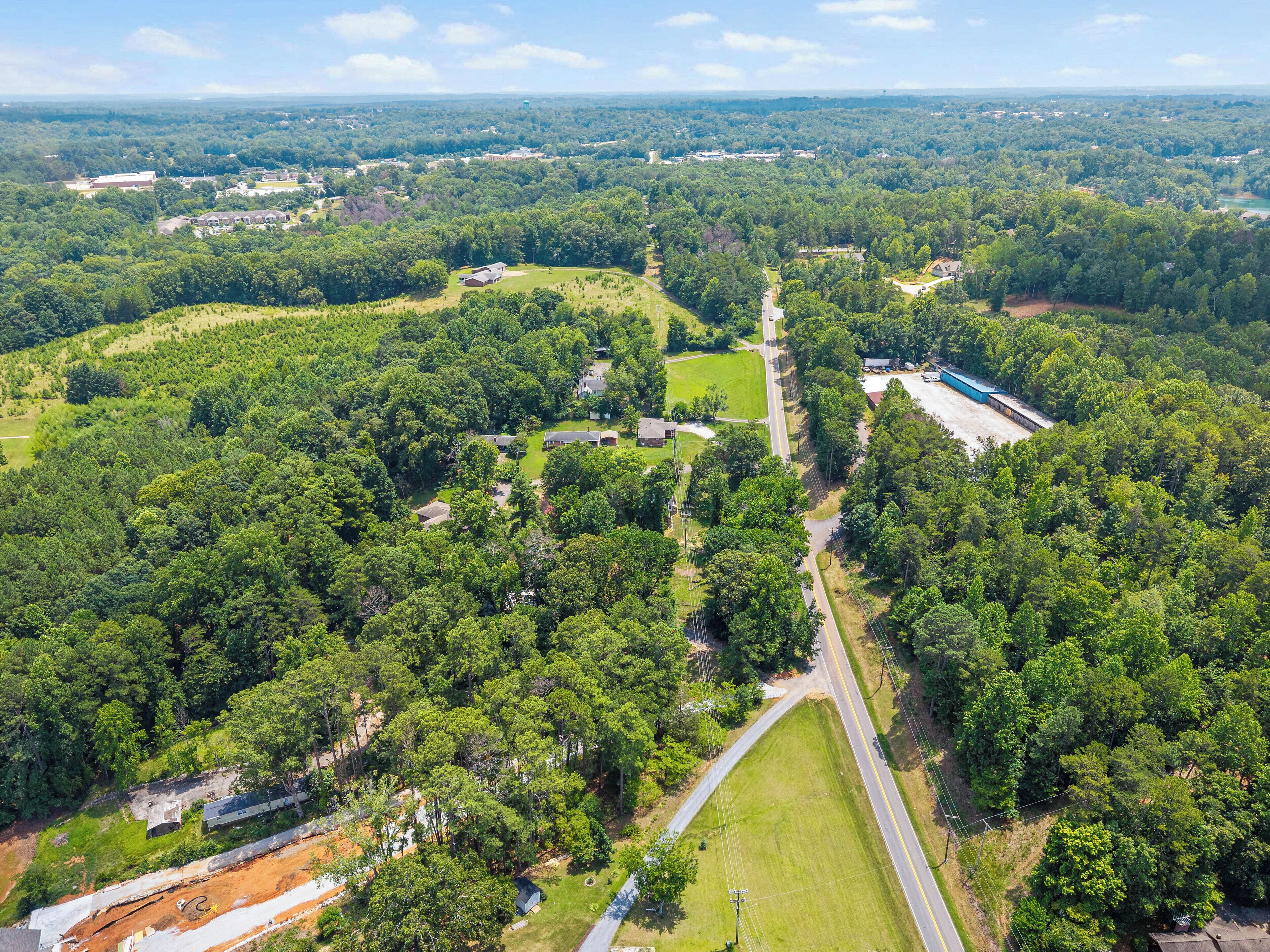 Vista aérea de una zona residencial con varias casas, carreteras y un amplio campo verde.