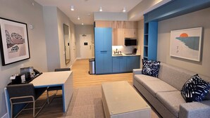 A modern living room with a sofa, a coffee table, and a dining area with a table and chairs.