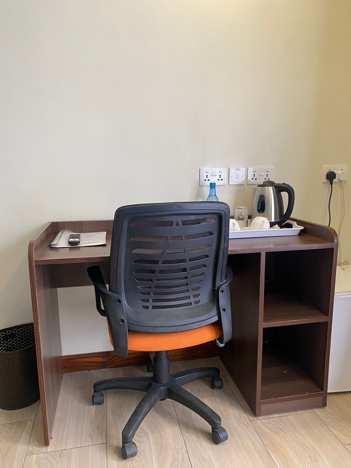 A workspace with a desk, chair, and electrical outlets.