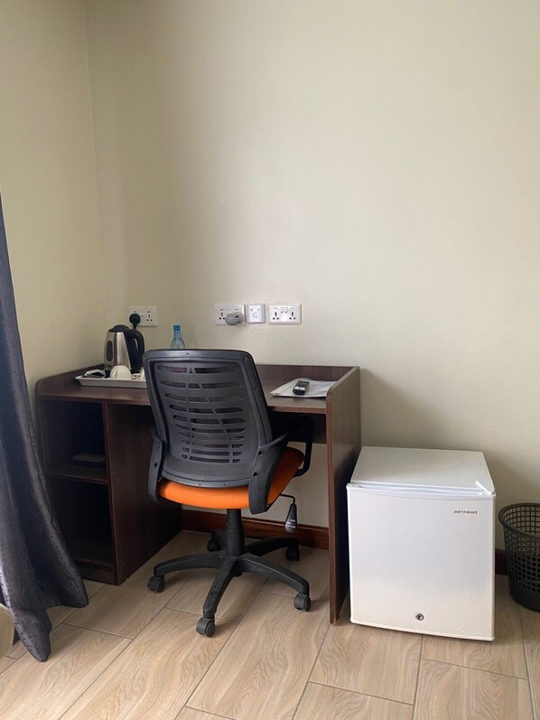 A corner office with a desk, chair, and a small white appliance. - Lake Naivasha Lazurus Lodge (Naivasha)