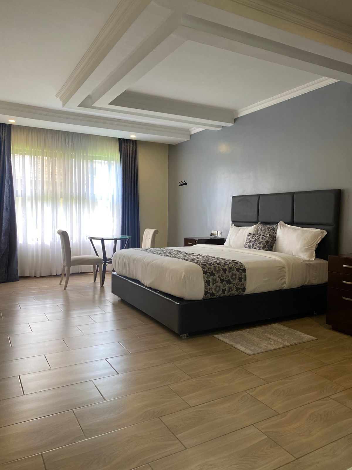 Ein modernes Schlafzimmer mit einem großen Bett, einem Sessel, einem Schreibtisch und einem Nachttisch.