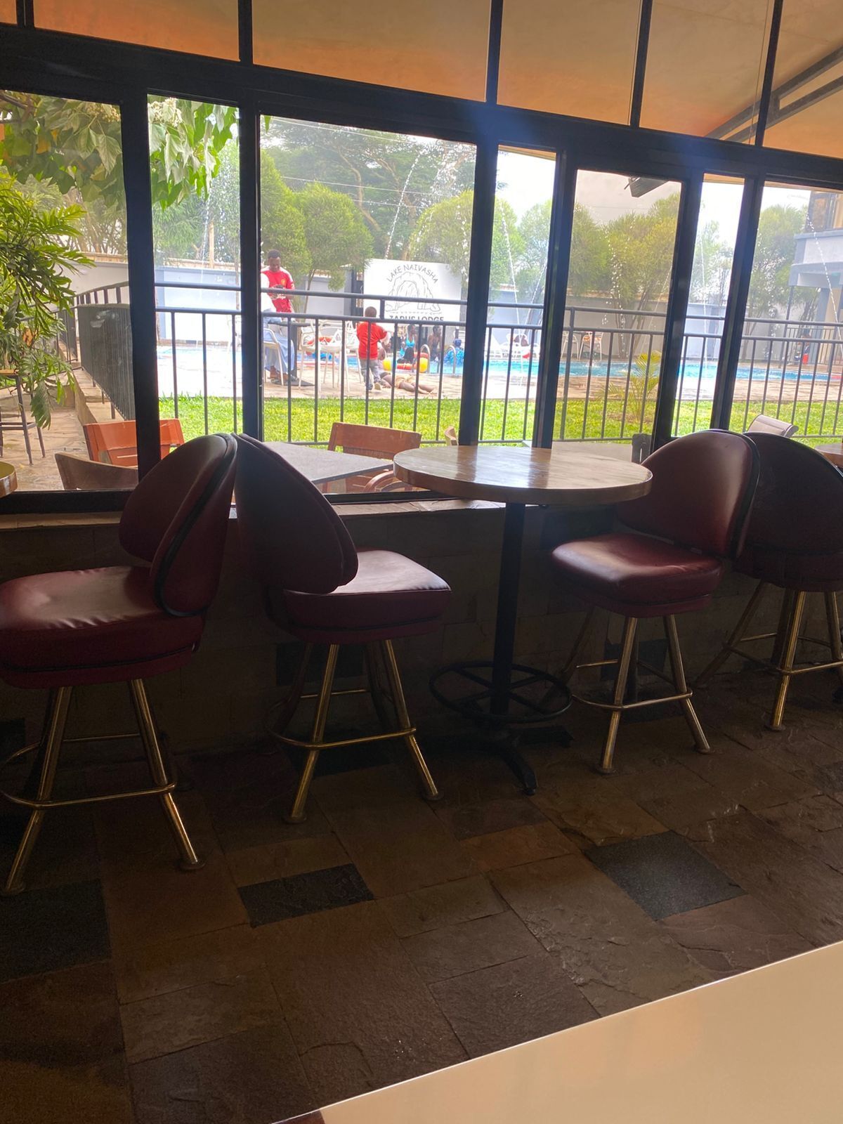 Un restaurante con vista a una piscina y terraza.