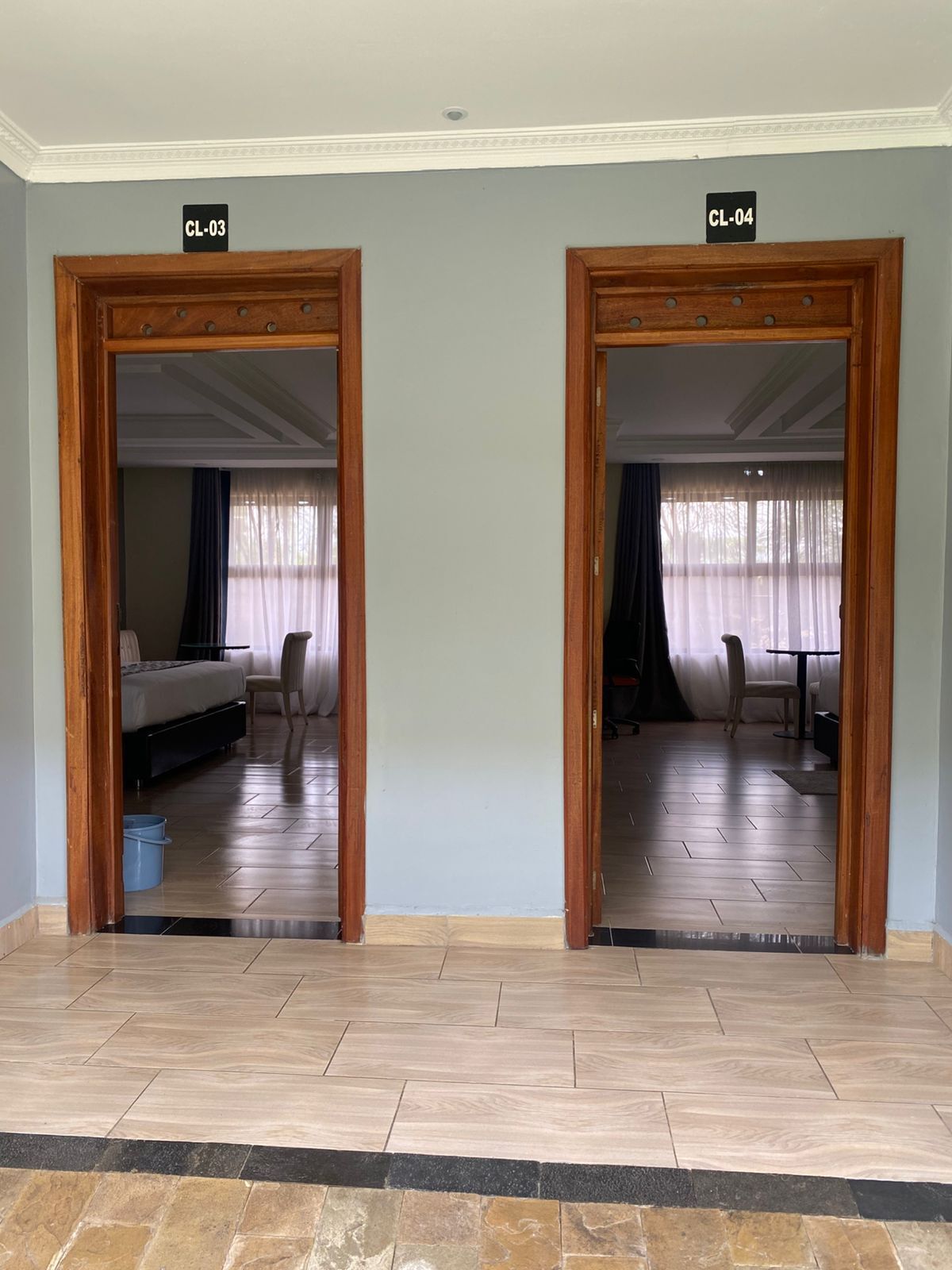 Two doors labeled CL-03 and CL-04 leading to rooms with beds, chairs, and a dining table.