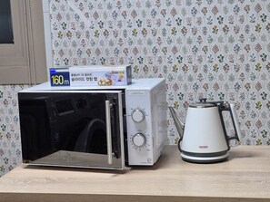 Cocina compacta con microondas, cafetera y una caja de producto de 160m.