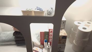 A shelf with books, a tissue box, and a bottle.