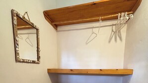 Een hoek met houten planken en een spiegel aan de muur.