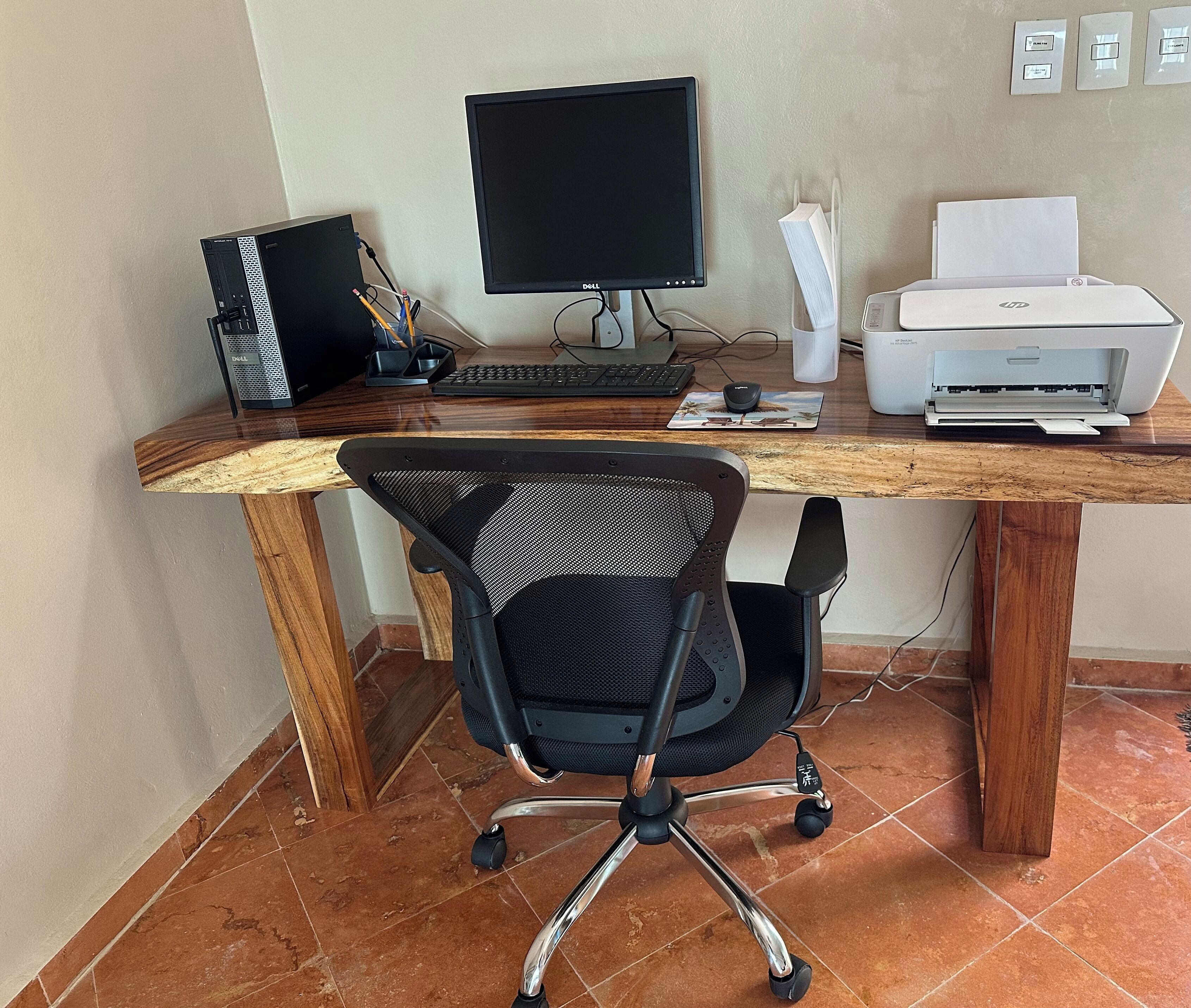 Un bureau en bois avec un ordinateur, un écran, un clavier, une souris et une imprimante.