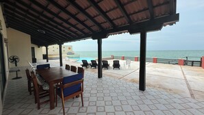 A covered outdoor area with a pool, lounge chairs, and a table. - Your Private Beachfront Retreat in Chelem, Yucatán (Chelem)