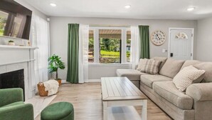 A living room with a fireplace, green curtains, a sofa, and a coffee table.