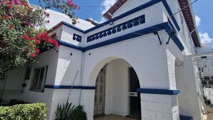 Un bâtiment blanc avec des bordures bleues et une entrée carrelée.
