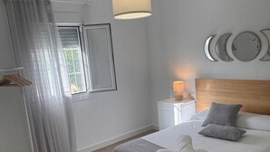 A bedroom with a bed, a bedside table with a lamp, a window with curtains, and wall decorations. - HOUSE ANA MARIA DISCONNECTION IN THE MOUNTAIN WITH INCREDIBLE VIEWS. PRIVATE SWIMMING POOL. (antequera)