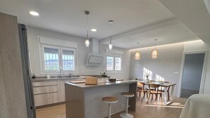 A modern kitchen with a central island, bar stools, and pendant lighting. - HOUSE ANA MARIA DISCONNECTION IN THE MOUNTAIN WITH INCREDIBLE VIEWS. PRIVATE SWIMMING POOL. (antequera)