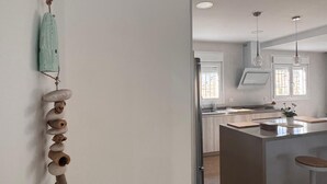 A modern kitchen with a central island, pendant lighting, and a rustic wall decoration. - HOUSE ANA MARIA DISCONNECTION IN THE MOUNTAIN WITH INCREDIBLE VIEWS. PRIVATE SWIMMING POOL. (antequera)