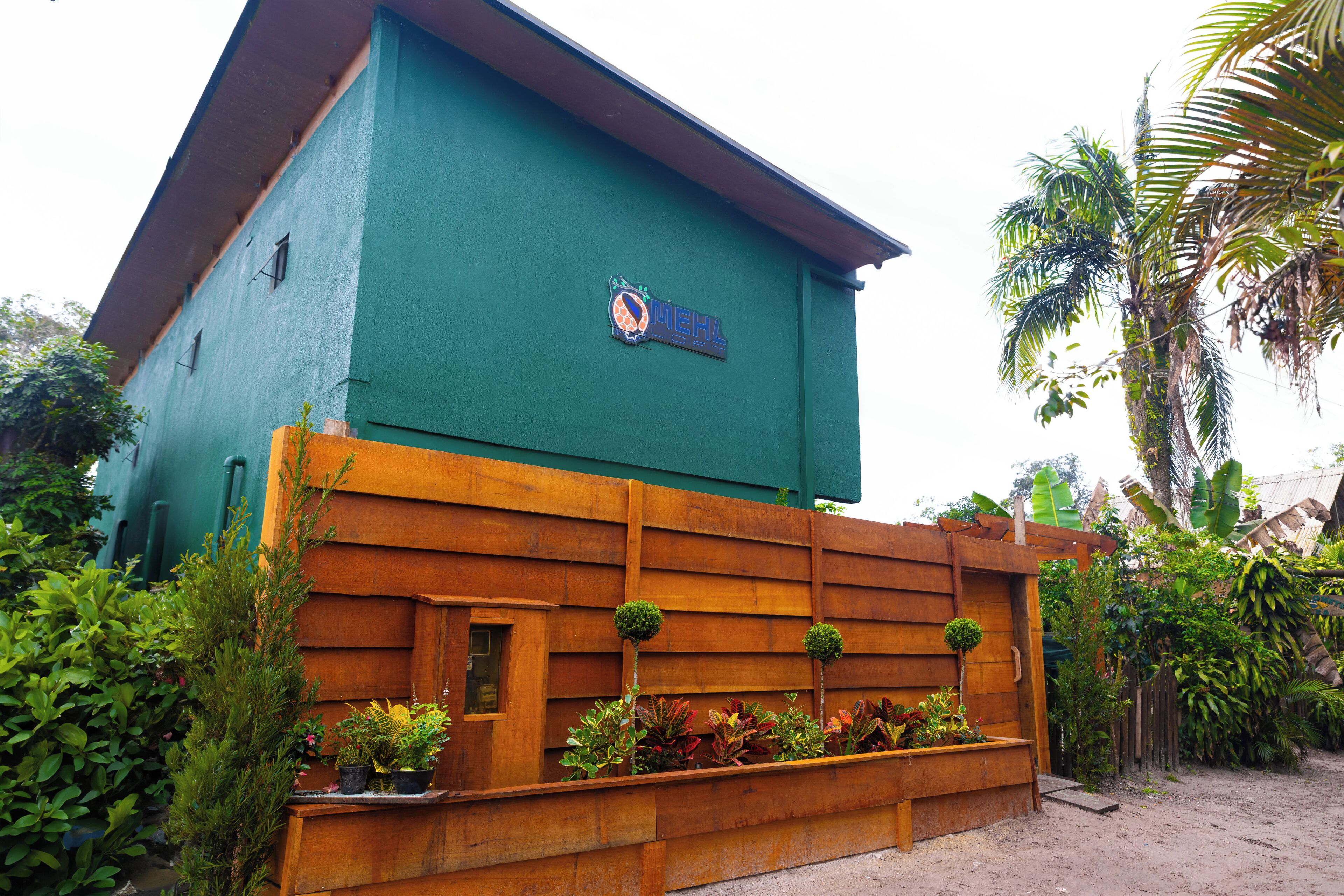 A building with a green exterior and a wooden lower section.