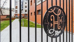 A gated entrance with a decorative sign featuring a stylized design.