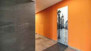 Ein Korridor mit Fliesenboden und einer orangefarbenen Wand.