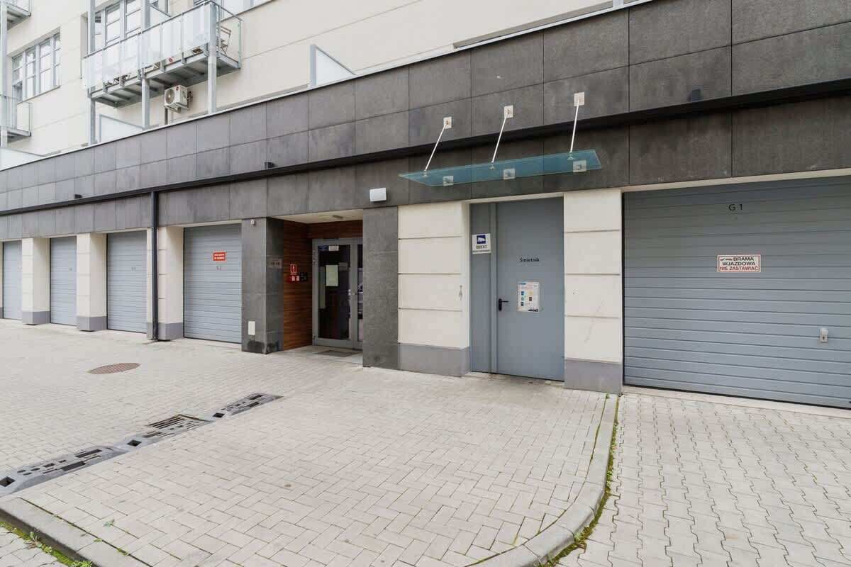 Ein Gebäude mit mehreren Garagentoren, einem deutlichen Eingang und einem Schild, das einen Parkplatz kennzeichnet.
